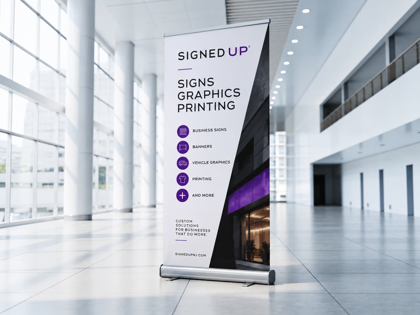 Signed Up retractable banner stand with a full-color graphic standing in a bright office lobby