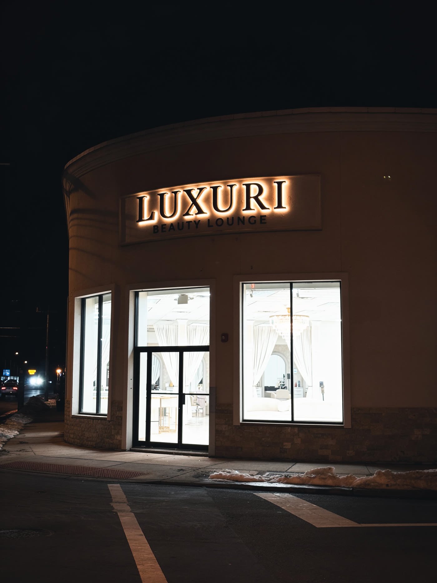 Halo-lit letters on a beauty lounge storefront at night